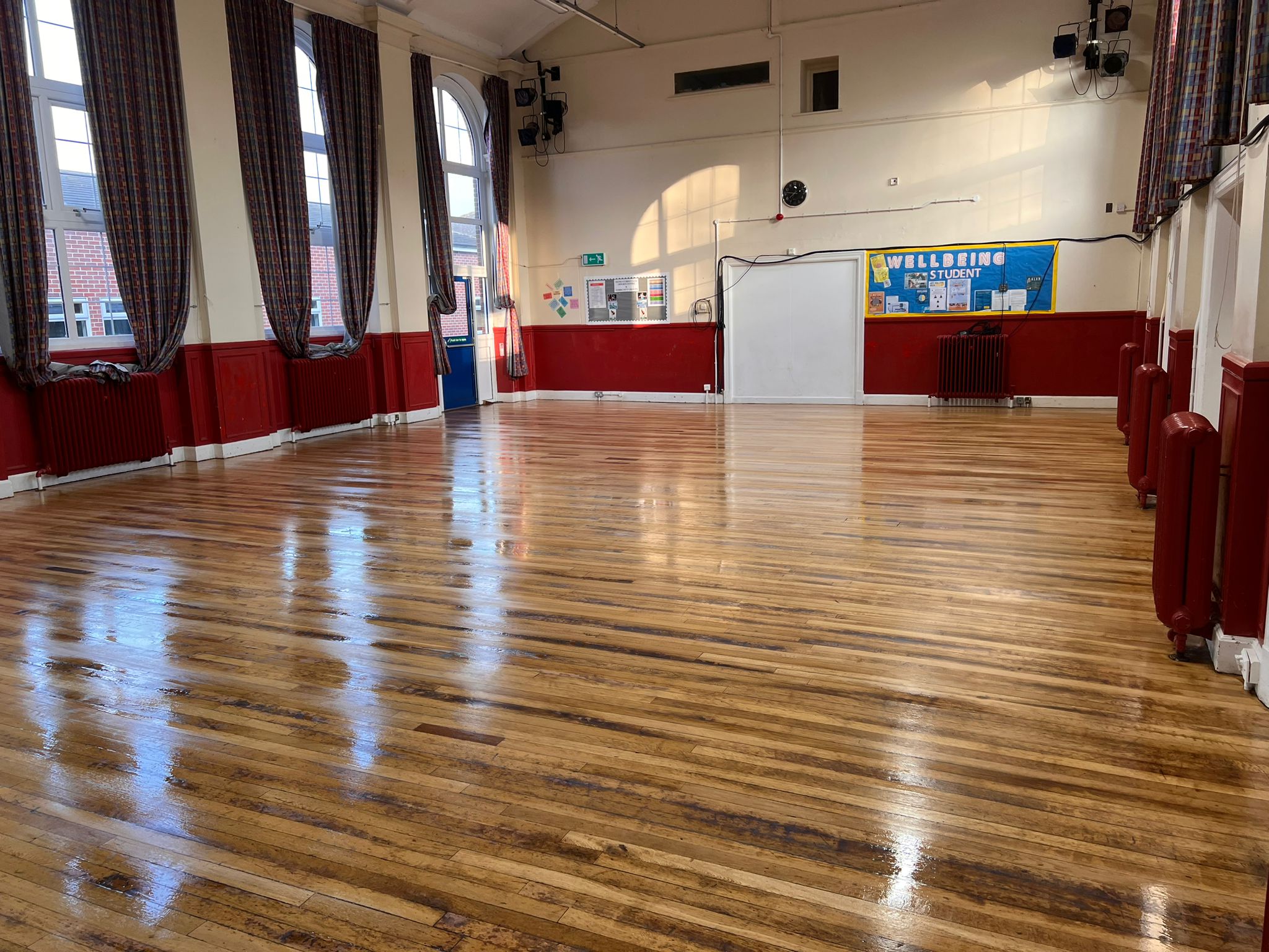 a School Hall wooden floor restoration, gleaming wooden floor in an old school hall with high windows